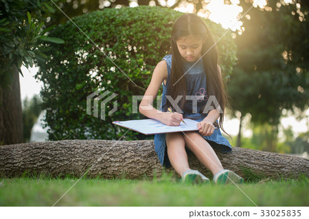 Happy Asian girl enjoying to draw pictures in park 33025835