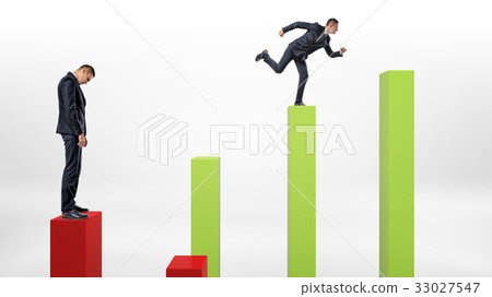 A sad businessman standing on a red column with a 33027547