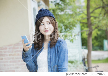 A woman watching a smartphone 33029822