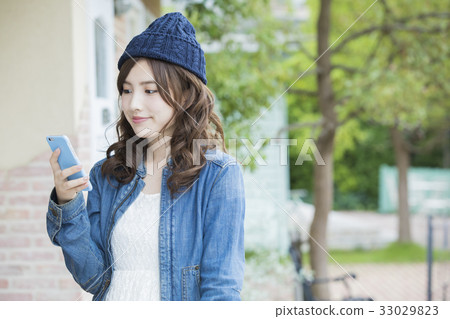 A woman watching a smartphone 33029823