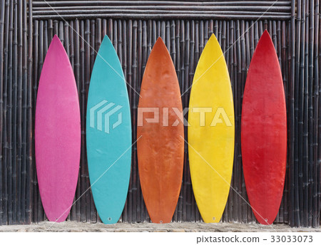 Colored surfboards leaning up against a wooden Colored surfboards leaning up against a wooden 33033073