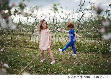 little boy and girl in blooming garden little boy and girl in blooming garden 33034287