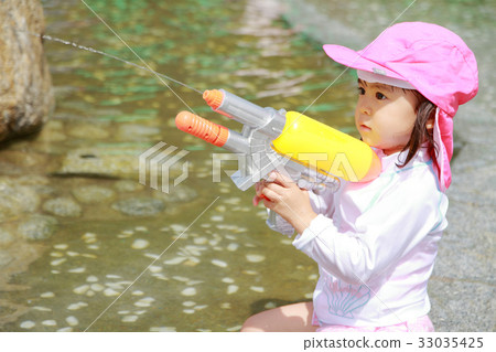 Toddler playing with water gun (2-year-old child) 33035425