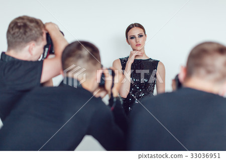 Photographers paparazzi take photos of woman in 33036951