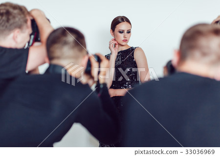Photographers paparazzi take photos of woman in 33036969