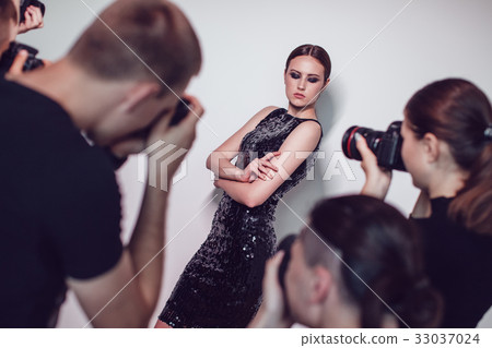 Photographers paparazzi take photos of woman in 33037024