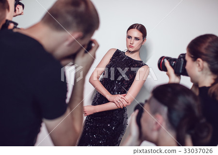 Photographers paparazzi take photos of woman in 33037026