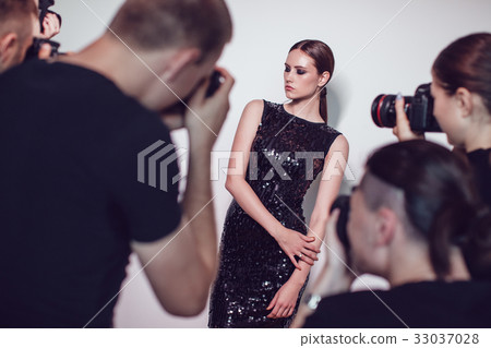 Photographers paparazzi take photos of woman in 33037028