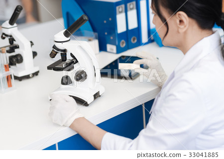 Nice intelligent woman working with a microscope Nice intelligent woman working with a microscope 33041885