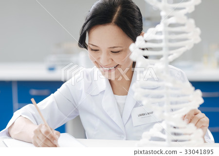 Happy biological engineer writing a report 33041895