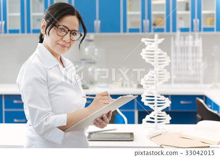 Positive female scientist holding her notes Positive female scientist holding her notes 33042015