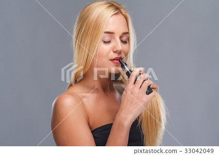 Young sexy blonde is vaping. Studio shooting, 33042049