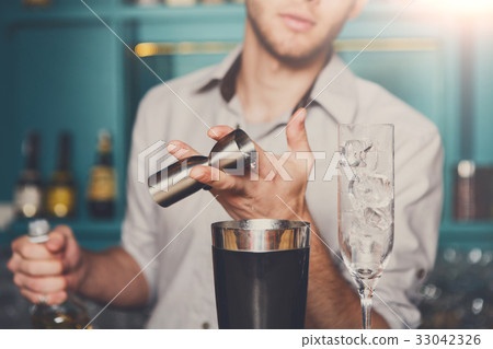 Bartender pouring syrup into measuring glass 33042326