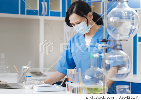 Serious good looking woman weighing the powder 33042517