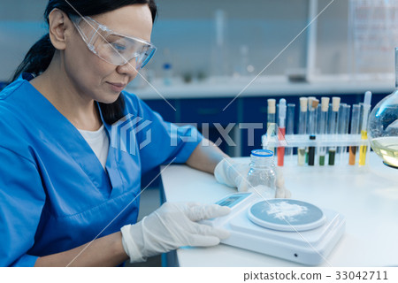 Smart nice woman working with electronic scales 33042711