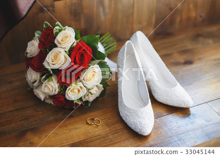 Wedding shoes and bouquet of red and white roses 33045144