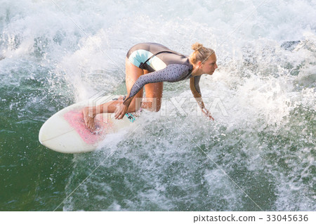 Atractive sporty girl surfing on famous artificial Atractive sporty girl surfing on famous artificial 33045636