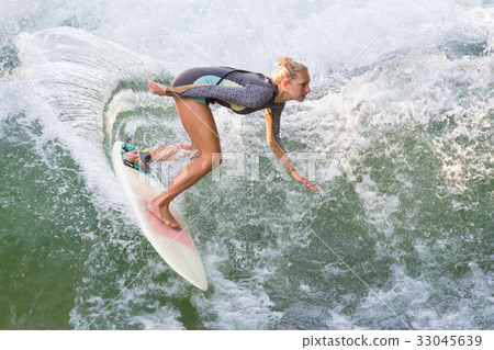 Atractive sporty girl surfing on famous artificial Atractive sporty girl surfing on famous artificial 33045639