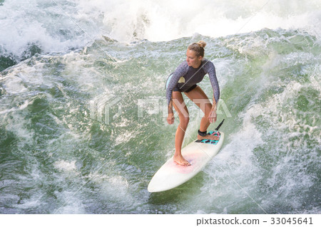 Atractive sporty girl surfing on famous artificial Atractive sporty girl surfing on famous artificial 33045641
