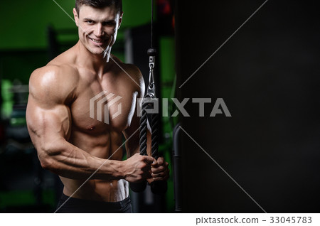 Muscular handsome athletic bodybuilder fitness model posing afte 33045783