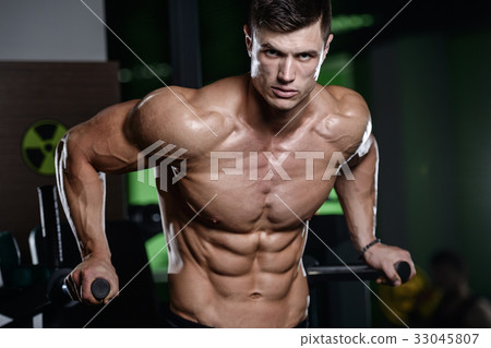 Muscular handsome athletic bodybuilder fitness model posing afte 33045807