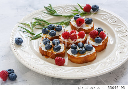 Crostini with ricotta, fresh berries and honey. 33046493
