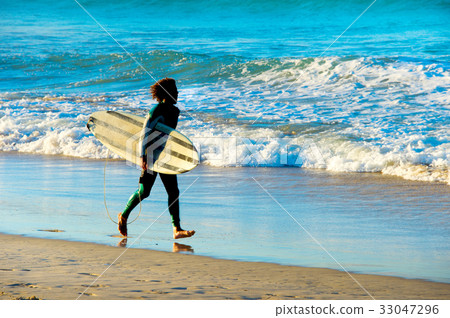 Surfer running with surfboard 33047296