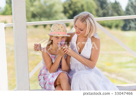 Mother with her liitle girl, daughter sniffing a 33047466