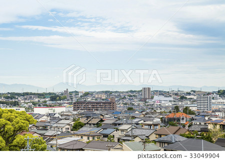 Overlooking a residential area where you can see mountains in the distance 33049904