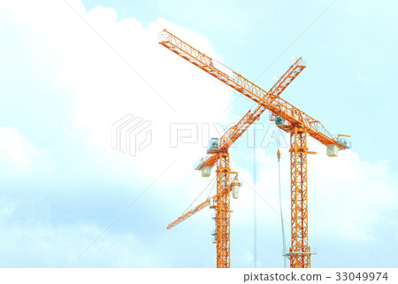 Two orange crane in cross on blue sky 33049974