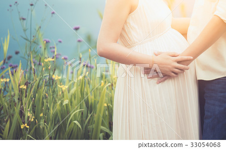 Pregnant woman and husband hugging on the tummy Pregnant woman and husband hugging on the tummy 33054068