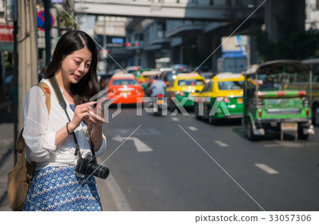 Asian backpacker woman using mobile phone app 33057306