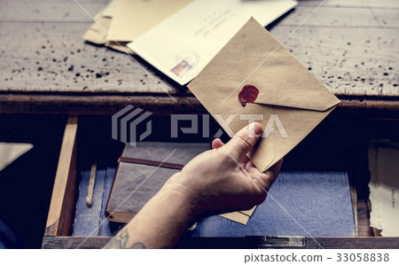 Human hand holding wax seal envelope correspondence 33058838
