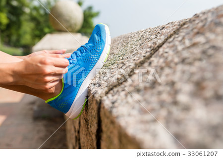Woman tying laces for jogging Woman tying laces for jogging 33061207