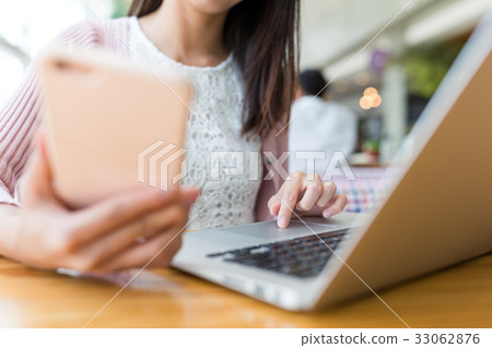 Woman use of cellphone and laptop computer 33062876