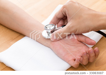Chinese Doctor checking patients pulse rate Chinese Doctor checking patients pulse rate 33063087