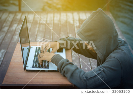 man wearing a hooded sweatshirt sitting hacker man wearing a hooded sweatshirt sitting hacker 33063100