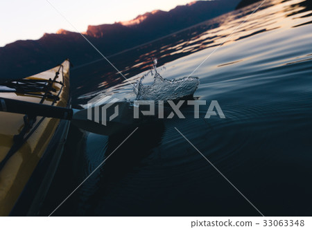 Kayaking on calm water while sunset 33063348