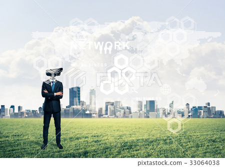Camera headed man standing on green grass against modern citysca 33064038