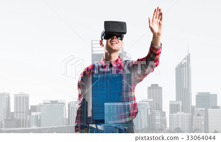 Guy wearing checked shirt and virtual mask stretching hand to touch something Guy wearing checked shirt and virtual mask stretching hand to touch something 33064044