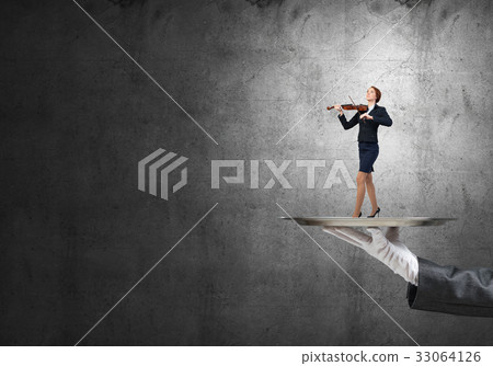Attractive businesswoman on metal tray playing violin against concrete background 33064126