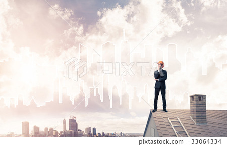Engineer man standing on roof and looking away. Mixed media 33064334