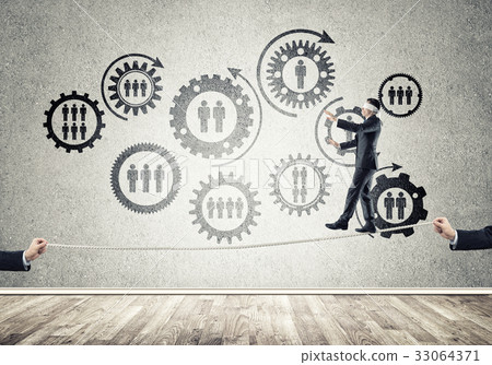 Business concept of risk support and assistance with man balancing on rope Business concept of risk support and assistance with man balancing on rope 33064371