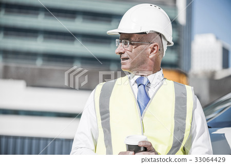 Engineer builder on construction site at sunny day with coffee i Engineer builder on construction site at sunny day with coffee i 33064429