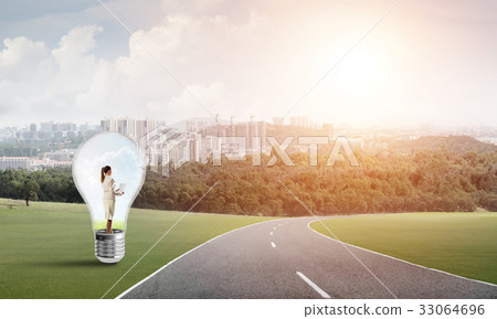 Businesswoman inside light bulb Businesswoman inside light bulb 33064696