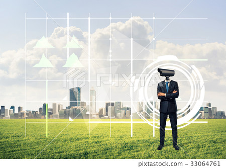 Camera headed man standing on green grass against modern citysca Camera headed man standing on green grass against modern citysca 33064761
