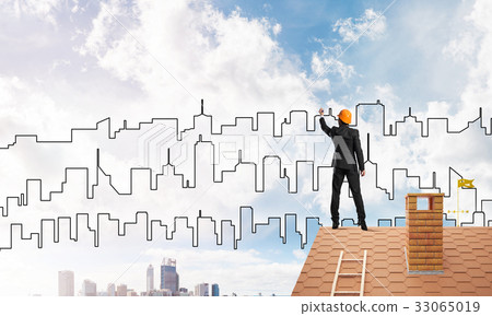 Man architect draw silhouette of modern city on blue sky. Mixed media 33065019