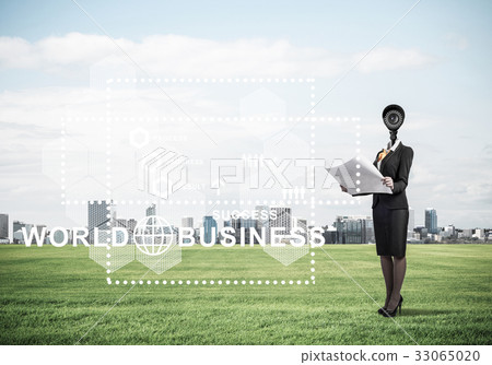 Camera headed woman standing on green grass against modern citys 33065020