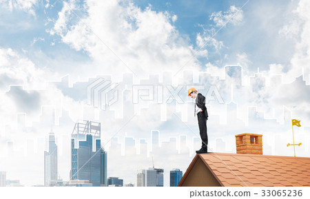Engineer man standing on roof and looking down. Mixed media Engineer man standing on roof and looking down. Mixed media 33065236