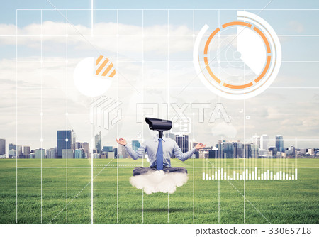 Camera headed man sitting in lotus pose on cloud against modern 33065718